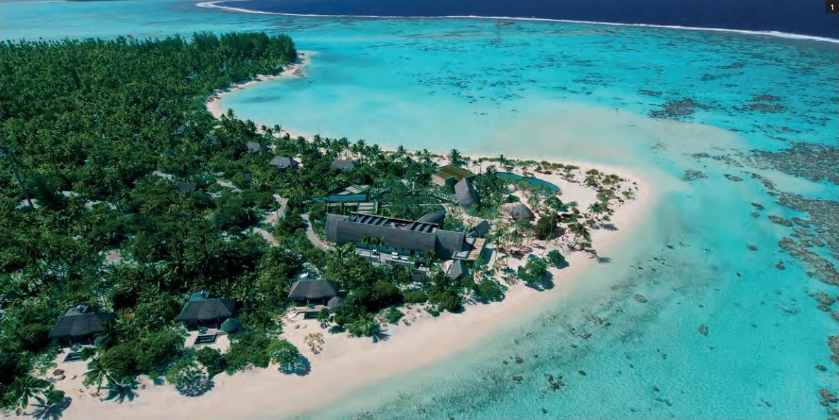 Vue aérienne de la pointe de l'atoll de Tetiaroa avec les villas du Brando parmi les cocotiers, la plage de sable blanc et le lagon turquoise.