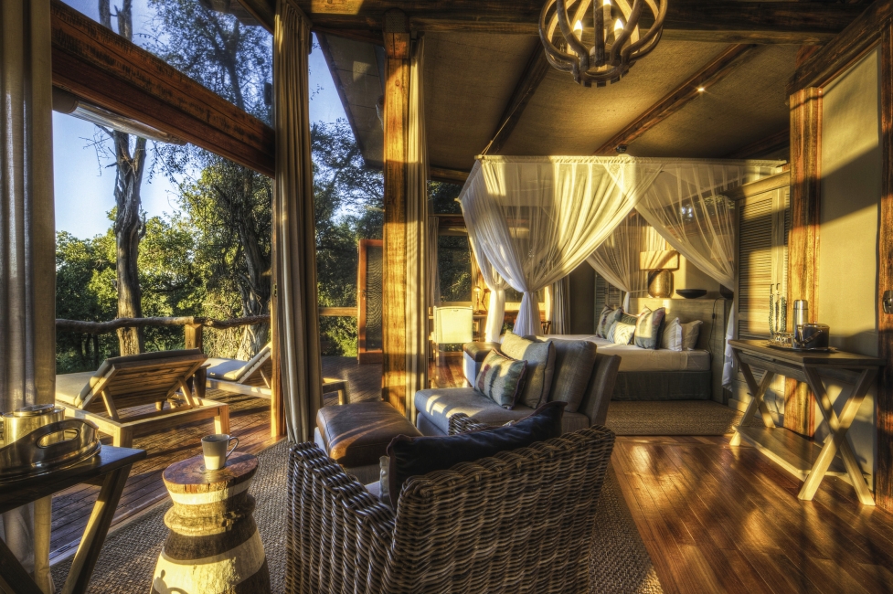 Chambre avec lit et fauteuil au Camp Okavango